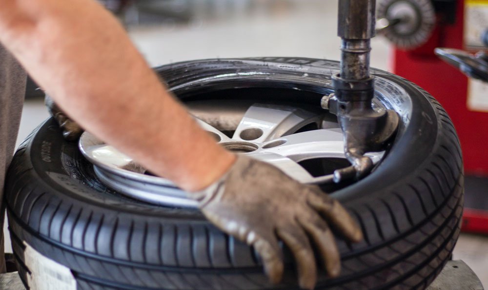 Technician performing tire services at Milstead Automotive in Spring TX