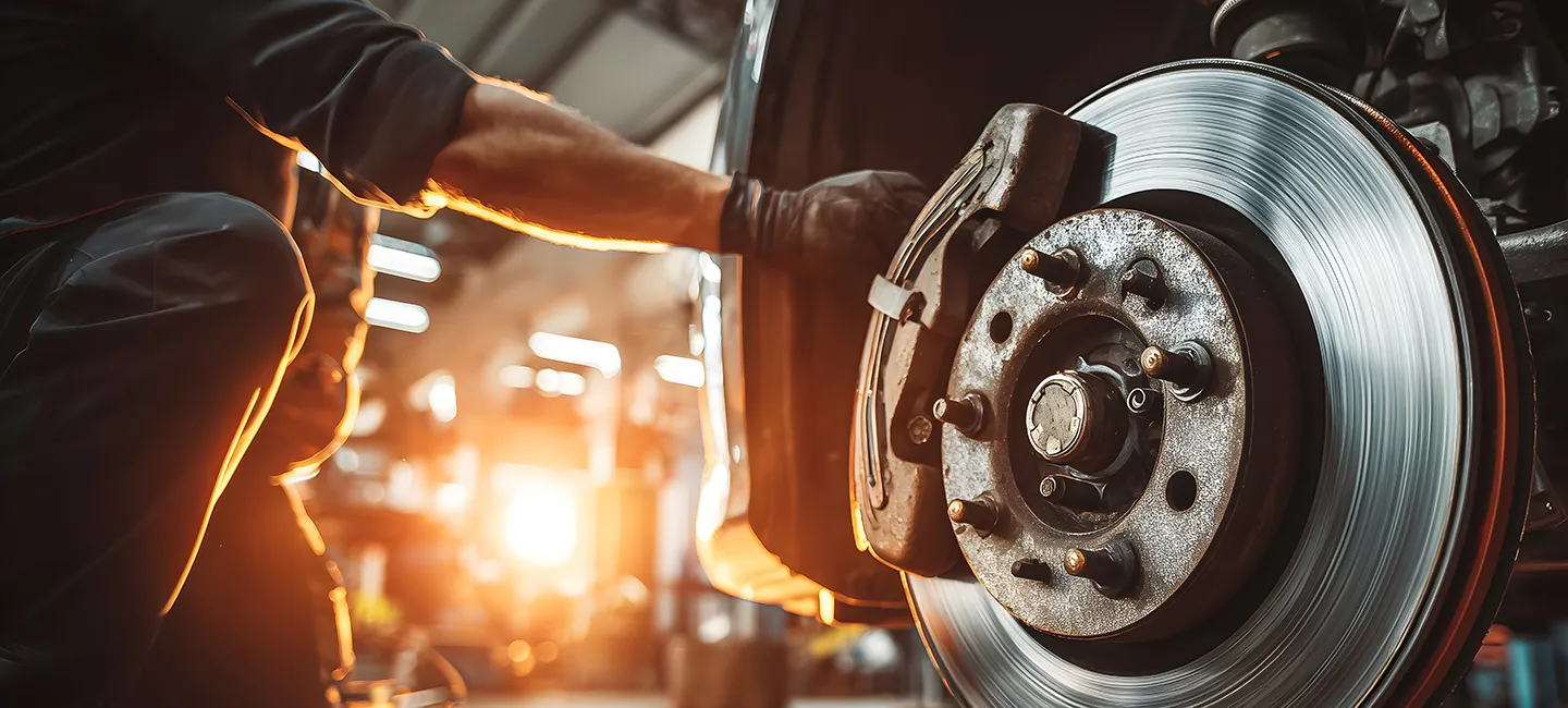 Mechanic installing new brake pads on a vehicle, illustrating brake pad replacement process