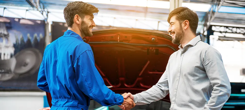 Satisfied customer discussing vehicle service with a mechanic at Milstead Automotive